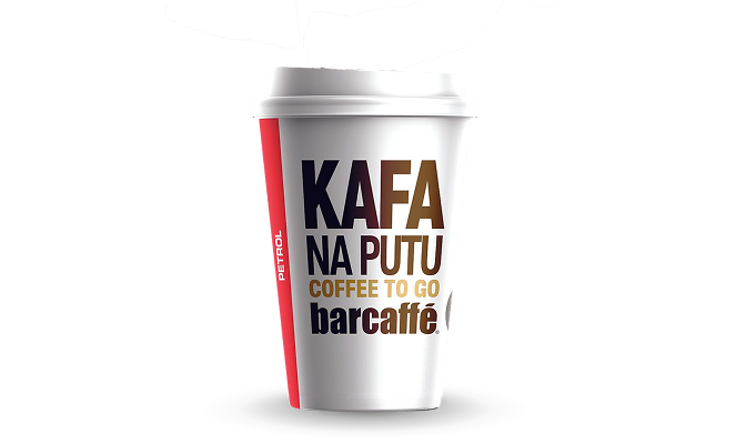 Na slici je papirna čaša za kafu sa poklopcem. Na čaši su istaknuti natpisi „KAFA NA PUTU“, „COFFEE TO GO“ i „barcaffè“, kao i Petrol logo sa bočne strane. Čaša je prikazana na crnoj pozadini.